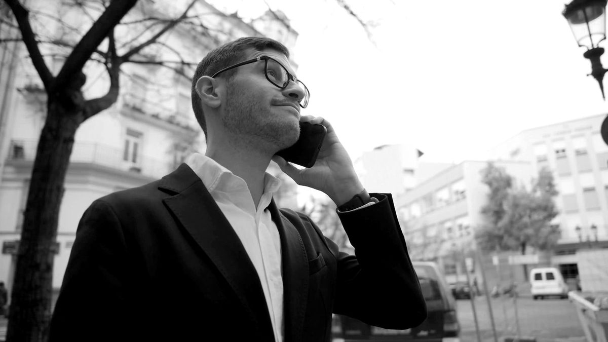 Santiago on a phone call in the street, black and white